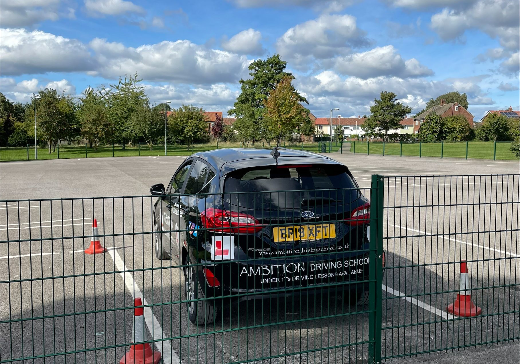Ambition driving school car parked in the fenced education village
